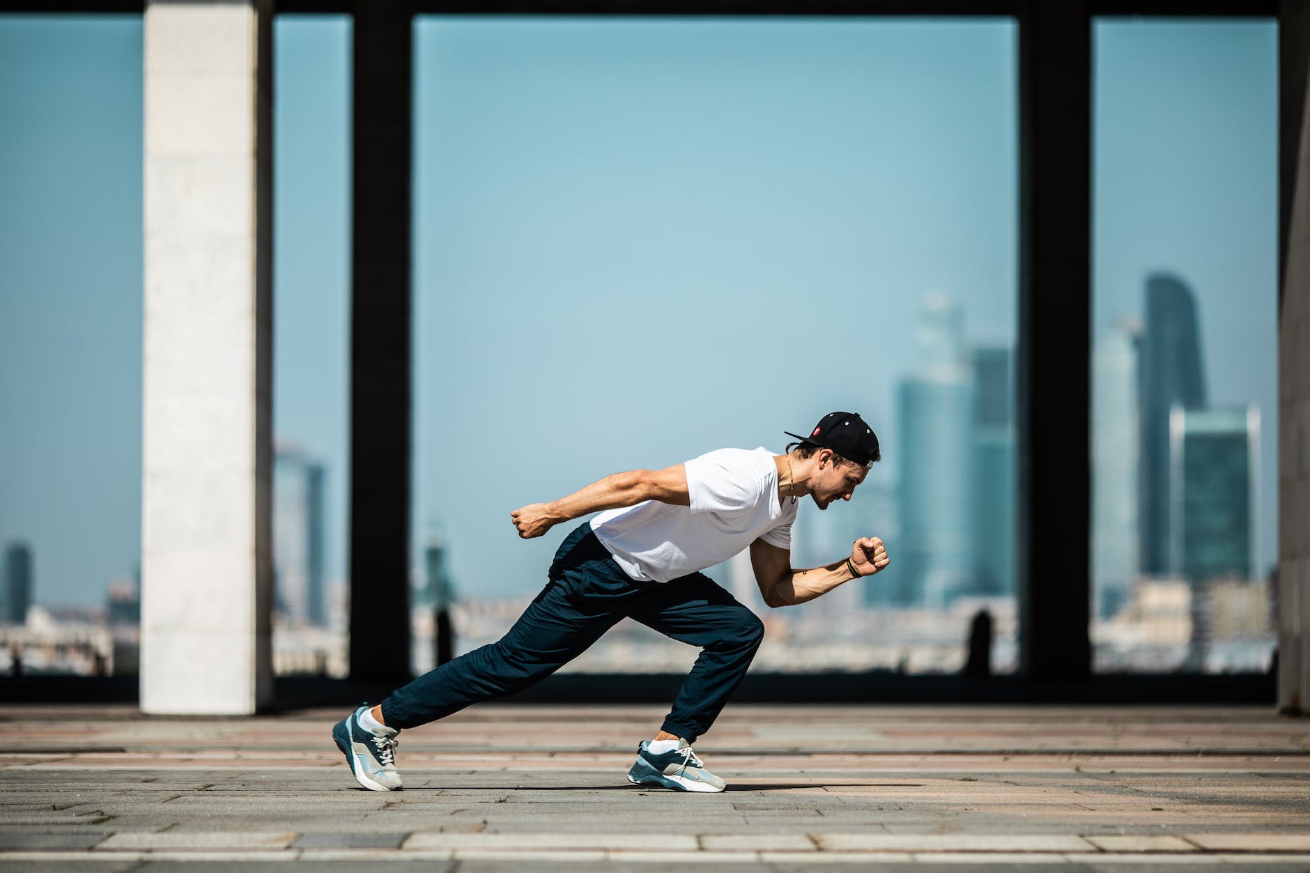 man in white t shirt and black pants in a running position