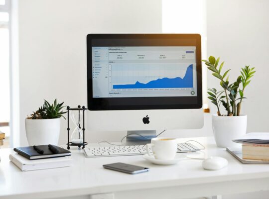 silver imac displaying line graph placed on desk